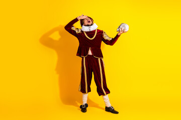 Actor Dressed as a Nobleman Performing Dramatically with a Skull on Yellow Background, to be or not...