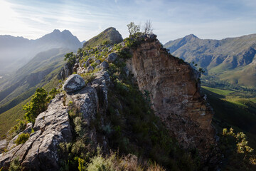 Landslide scar from a recent rockfall on a bushy mountain ridge