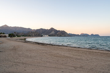 Strand von Maskat bei Sonnenuntergang mit Bergen