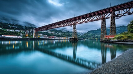 Fototapeta premium A bridge spanning across a river, with massive steel trusses supporting it.
