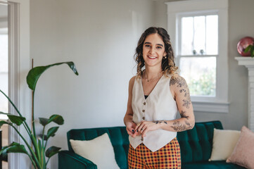 Young Tattooed Woman Standing in a Living Room