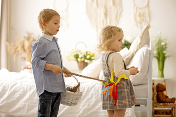 Happy children, siblings, enjoying Easter holiday together, tradition with handmade twig, braided whip made from pussy willow