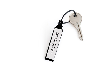 The key and keychain are made of plastic with the inscription RENT. The concept of real estate transactions.