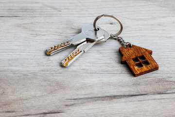 House of cranes with keys on wooden table. Concept of sale, rent, real estate insurance.