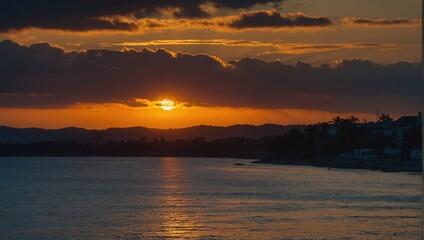 Obraz premium Striking Sunset Scenery over Dark Coastline, with Golden Sun Hiding Behind Clouds, Shimmering on Waters, Silhouette of Distant Hil