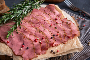 Sliced pastrami meat with rosemary and pepper