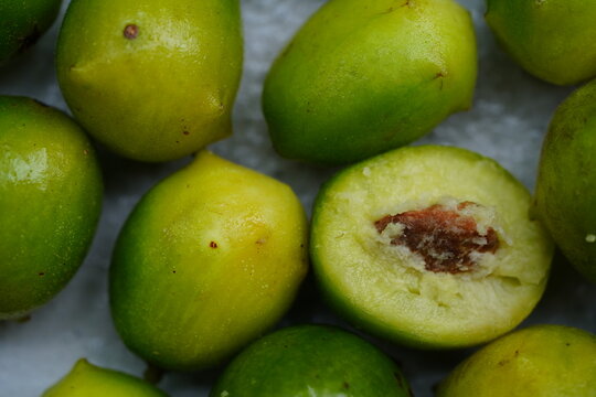 Green and ripe umbu fruit (Spondias tuberosa), also known as Brazil plum. A fruit cut open in cross-section.  Fruits are edible, sweet and sour and also good against diabetes. Lajes, RN, Brazil.