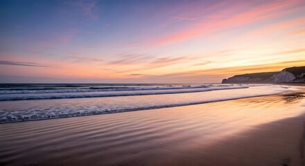 Naklejka premium A peaceful beach at sunset, with soft pink and orange hues in the sky, waves gently rolling onto the sand, and a silhouette of distant cliffs, Ai Generated