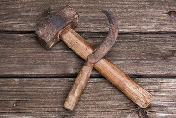 Old rusty hammer and sickle wooden surface