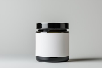 A jar with a white label sits on a white background. The jar is made of glass and has a black lid