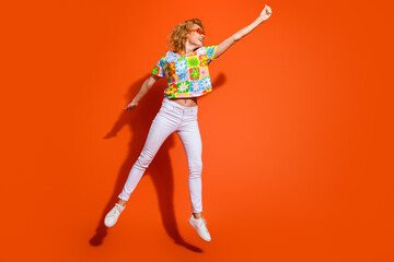 Stylish Young Woman Joyfully Posing in Vibrant Summer Outfit Against Bold Orange Background,...