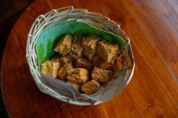Tahu sutra, indonesian traditional food from sundanese west java, made from deep fried tofu with silky texture, served on traditional bamboo basket