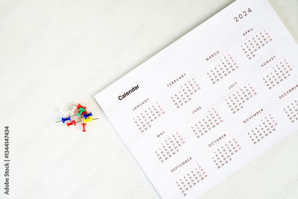 Poster calendar with stack of colorful pin on the table