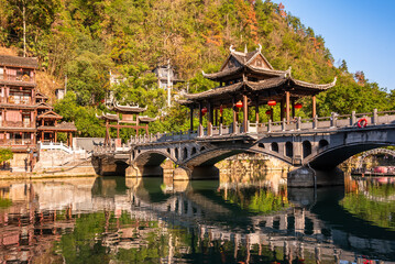 Fototapeta premium Old bridge in Fenghuang ancient town, China. Traditional chinese wooden houses in old watertown