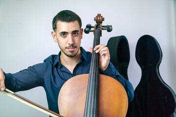 Young musician playing cello with bow and strings on white background.. © pabscal