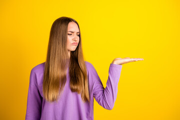Young Woman in Purple Shirt Gesturing with a Puzzled Expression on a Yellow Background with Hand...