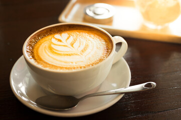 Hot latte coffee cup on wooden table.