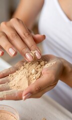 Women's hands hold sand or cosmetic clay. Vertical macro photo of cosmetics, close up
