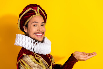 Playful young man in noble attire showcased against a vibrant yellow background