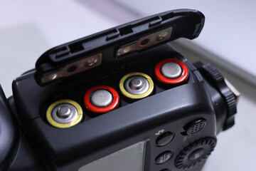 The battery compartment for photographic equipment shows the positive and negative terminals.