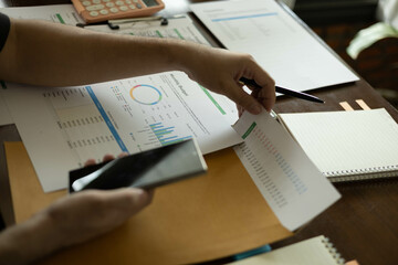 the businessman is sitting at a desk with a calculator and a stack of papers. She is looking at the...