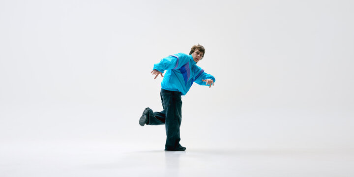 Powerful b-boy move showcasing flexibility, energy, and raw talent as dancer flows into floor transition against white background. Concept of music, urban culture, rhythm, expression, movement.