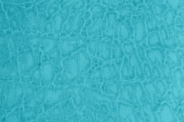 Textured background of blue color crocodile leather. Blue leather texture with an intricate organic pattern. Elegant and stylish surface perfect for modern fashion, upholstery