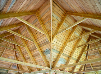 View from the inside of a solid wooden roof structure of complex shape