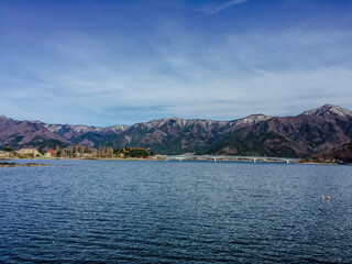 Fototapeta premium Lake Kawaguchiko Scenic View, Japan: Bridge, Mountain Scape, and Serene Waters