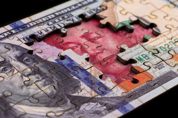 Naklejka premium Puzzle pieces of $100 and 100 Chinese yuan bills