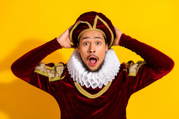 Young man dressed as a nobleman with a surprised expression against a vibrant yellow background