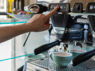 Young waitress pressing the button on a professional coffee machine in a small hospitality business