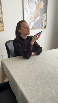 Mulher trabalha com celular em casa 
