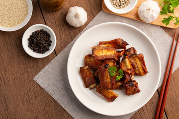 Air fryer fried Crispy pork spare ribs with garlic and pepper in white plate.oil free food.Healthy cooked.Top view.