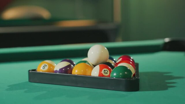 Close-up view of colorful billiard balls neatly arranged in triangle rack on green pool table, with vibrant colors and soft lighting highlighting their texture and smooth surface in a cozy game room