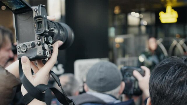 Videographers filming press conference with mirrorless cameras