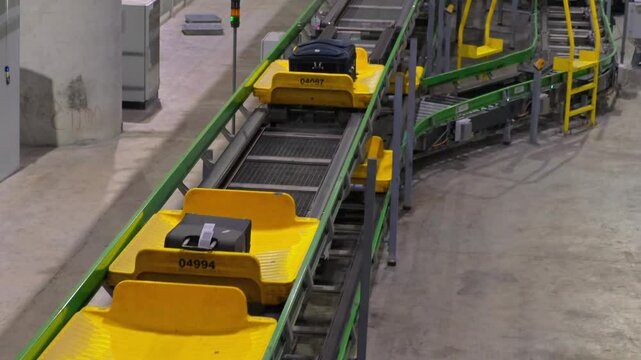 Moving luggages passes on airport baggage conveyor belts. Unmanned shooting. High-tech luggage handling system