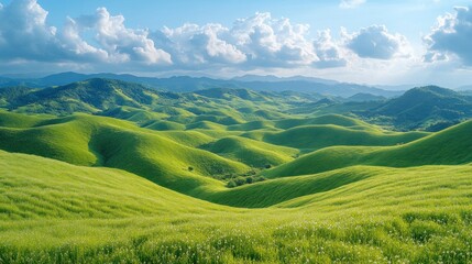Fototapeta premium Lush green rolling hills and mountains under a partly cloudy sky.