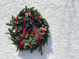 Wianek świąteczny na śniegu, Boże Narodzenie, kartka świąteczna, czerwone ozdoby bożonarodzeniowe. Christmas decorations.
