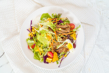 Mixed fruit and vegetable salad on a simple background