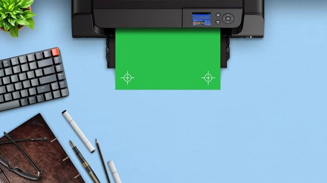 Printer printing template on top of blue office desk, Top View Printer with gaming keyboard, ancient book, pens, glasses and a green healthy plant