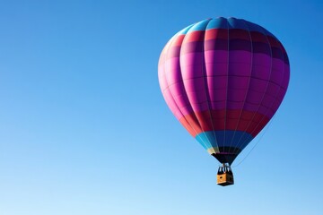 Naklejka premium vibrant hot air balloon floats gracefully against clear blue sky backdrop offering ample copy space for text placement