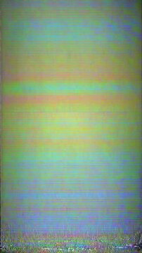 A distorted VHS screen with horizontal color glitches in green, yellow, blue, and pink tones. The lower part is more blurred and noisy