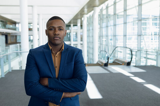 Confident businessman in blue suit standing in modern conference center, copy space