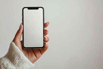 A person holding a modern smartphone with a blank screen