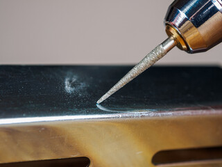 A close-up of an engraver tool, designed for carving into wood and metal. Detailed sharp, precision-focused.