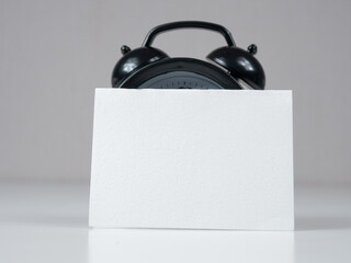 A blank reminder sticker and alarm clock inspire productivity, creating space for ideas and plans.