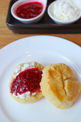 Mouthwatering Scone Topped with Whipped Cream and Raspberry Jam