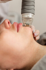 Attractive young woman undergoing a cosmetic procedure in a beauty salon. A woman undergoes...