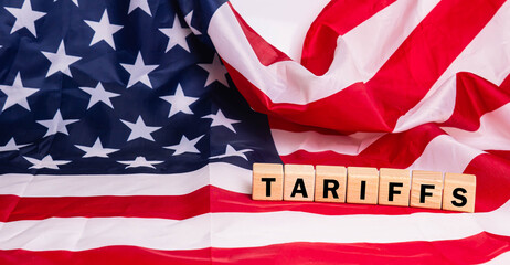 Wood cube tariffs aword on Flag of the United States of America background.
Tariff USA trade war...